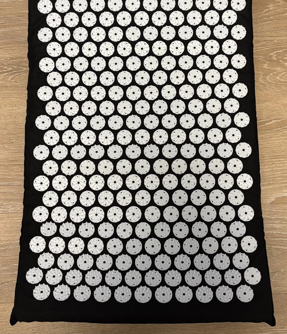 Customer photo of the black acupressure mat unrolled on a light wood floor
